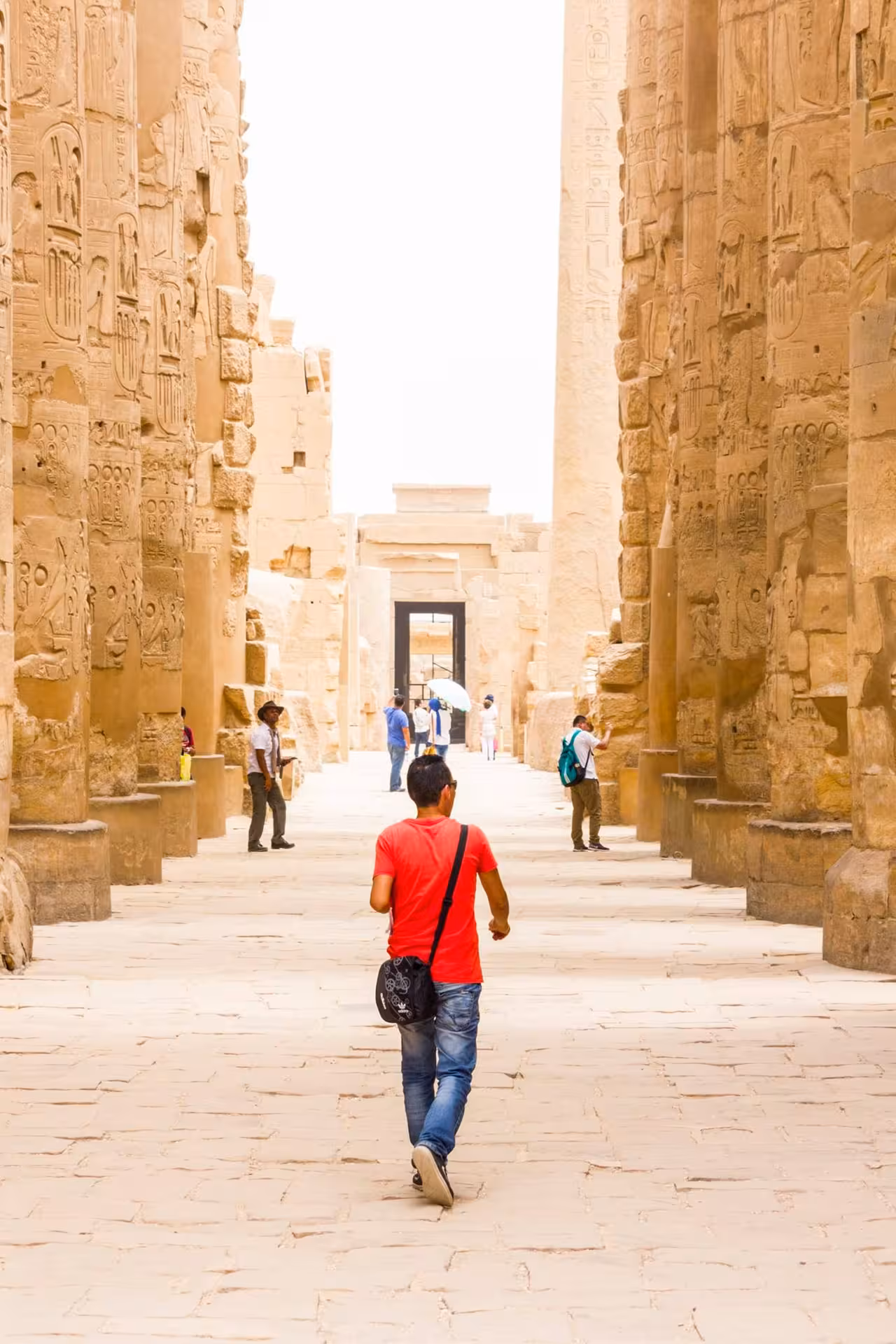 Travelers walk through Karnak Temple avenue of columns in Luxor on Nile Pearl 5-star Nile cruise excursion