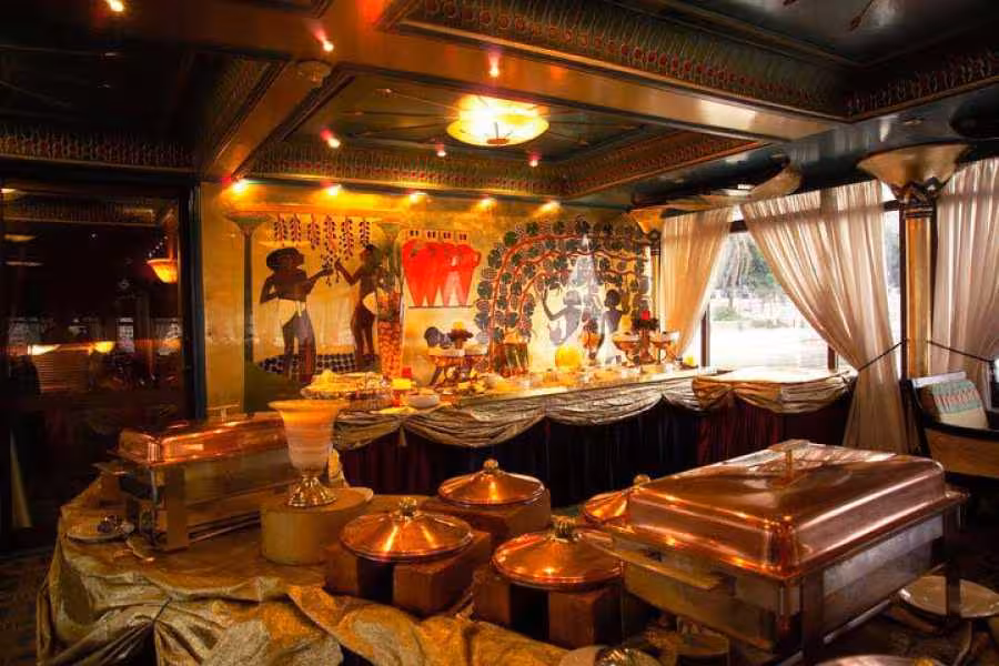 Pharaoh-themed buffet dining on a Nile cruise ship, luxury Egypt river cruise booking with authentic decor