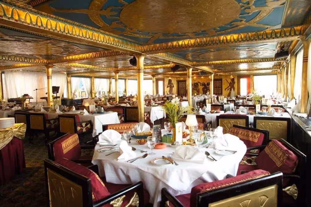 Elegant dining room on Nile Pharaohs cruise with Egyptian decor, set tables, and onboard dinner service