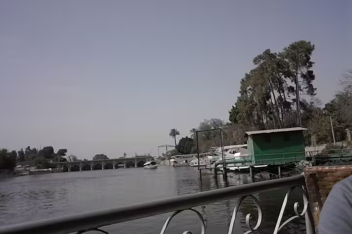 Nile River view in Cairo with boats and riverside trees, scenic stop on Manial Palace and Cairo Tower day tour