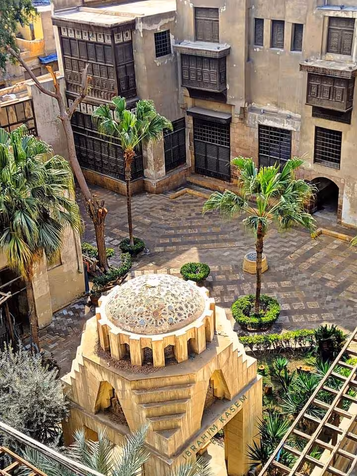 Historic courtyard with palm trees and architecture, showcasing cultural heritage on the Valley of the Nile tour.