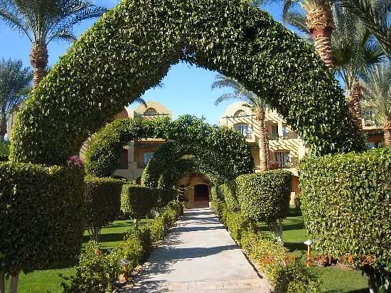 Lush green archways and manicured gardens leading to a charming resort in the Valley of the Nile.