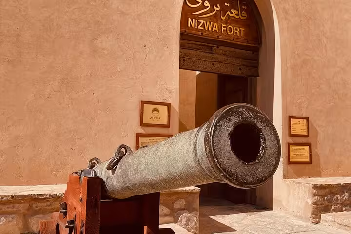 Old cannon guarding the entrance of Nizwa Fort, a highlight of private evening cultural and history tours in Oman