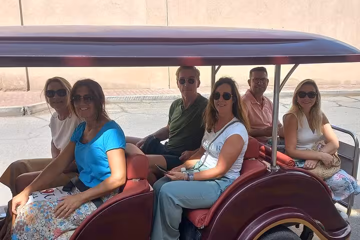 Small group of tourists riding an open electric cart through Nizwa streets on a comfortable full-day guided city tour