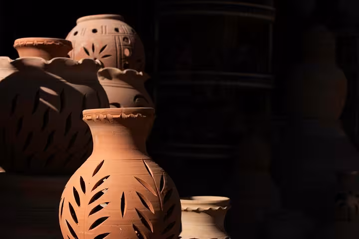 Traditional Omani clay lanterns and pottery in warm light, showcasing Nizwa souq handicrafts on the Nizwa by Night tour