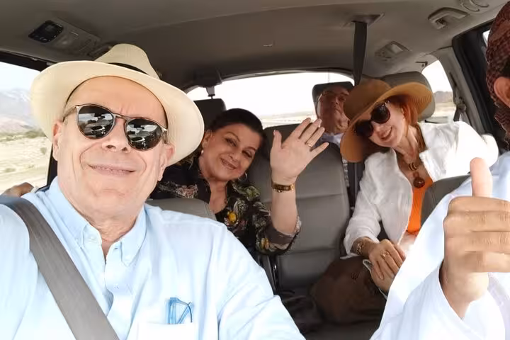 Happy small group inside a comfortable minivan during the Nizwa by Night sightseeing tour transfer through Oman’s mountain scenery