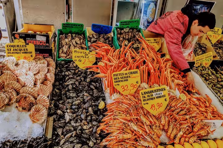 Seafood stall at Noailles market Marseille with crab legs, oysters and langoustines on exotic food tour
