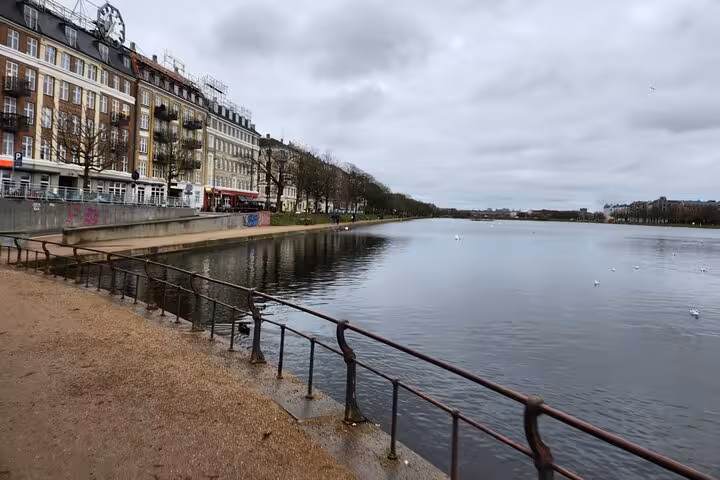 Scenic view of a serene Copenhagen canal lined with historic buildings, ideal for a walking tour exploring Danish life.