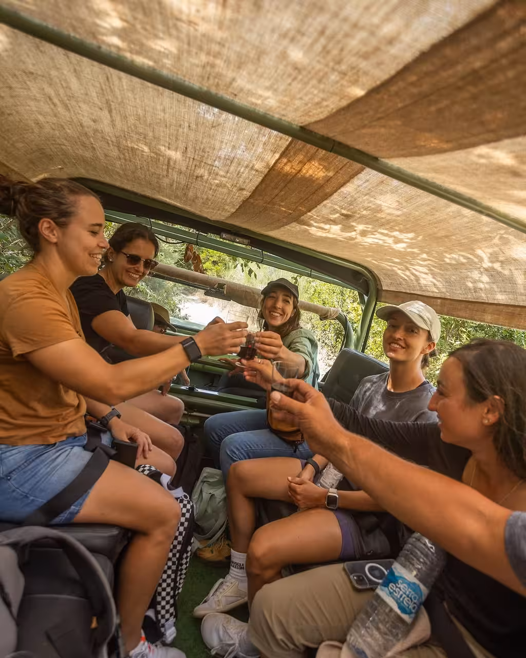 Guests toast inside vintage 4x4 on North Coast Adventure tour, enjoying nature and culture ride