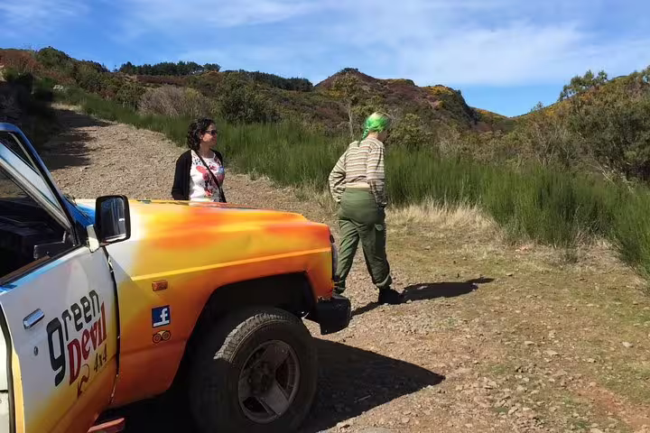 Tour participants exploring rugged terrain with a colorful 4x4 vehicle on the Santana adventure.