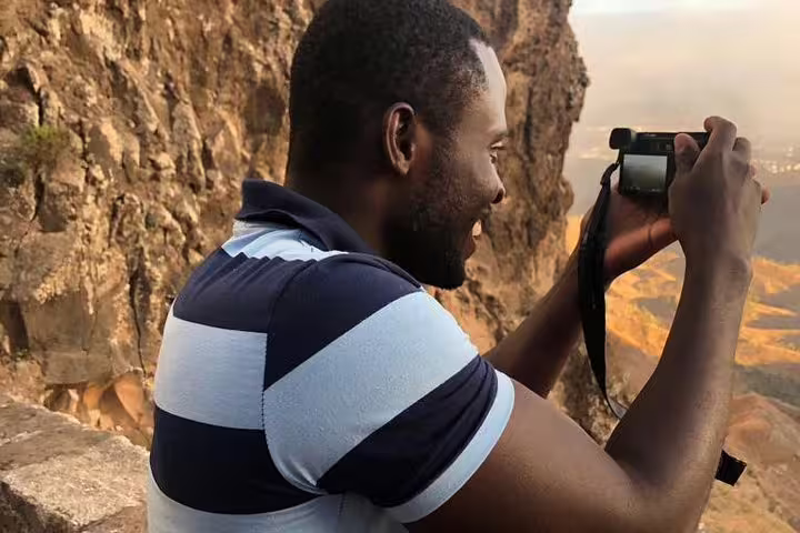 Traveler capturing views of rocky cliffs on the Full-day Northeast Coast Tour.