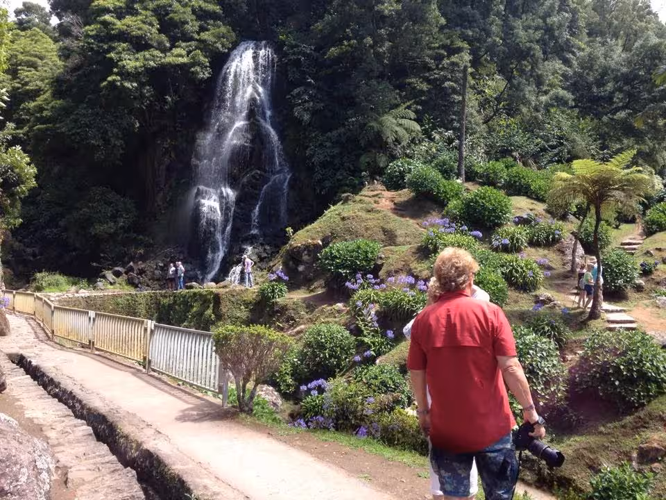 Traveler on Northeast van scenic tour visits lush garden waterfall viewpoint on full-day settlement excursion
