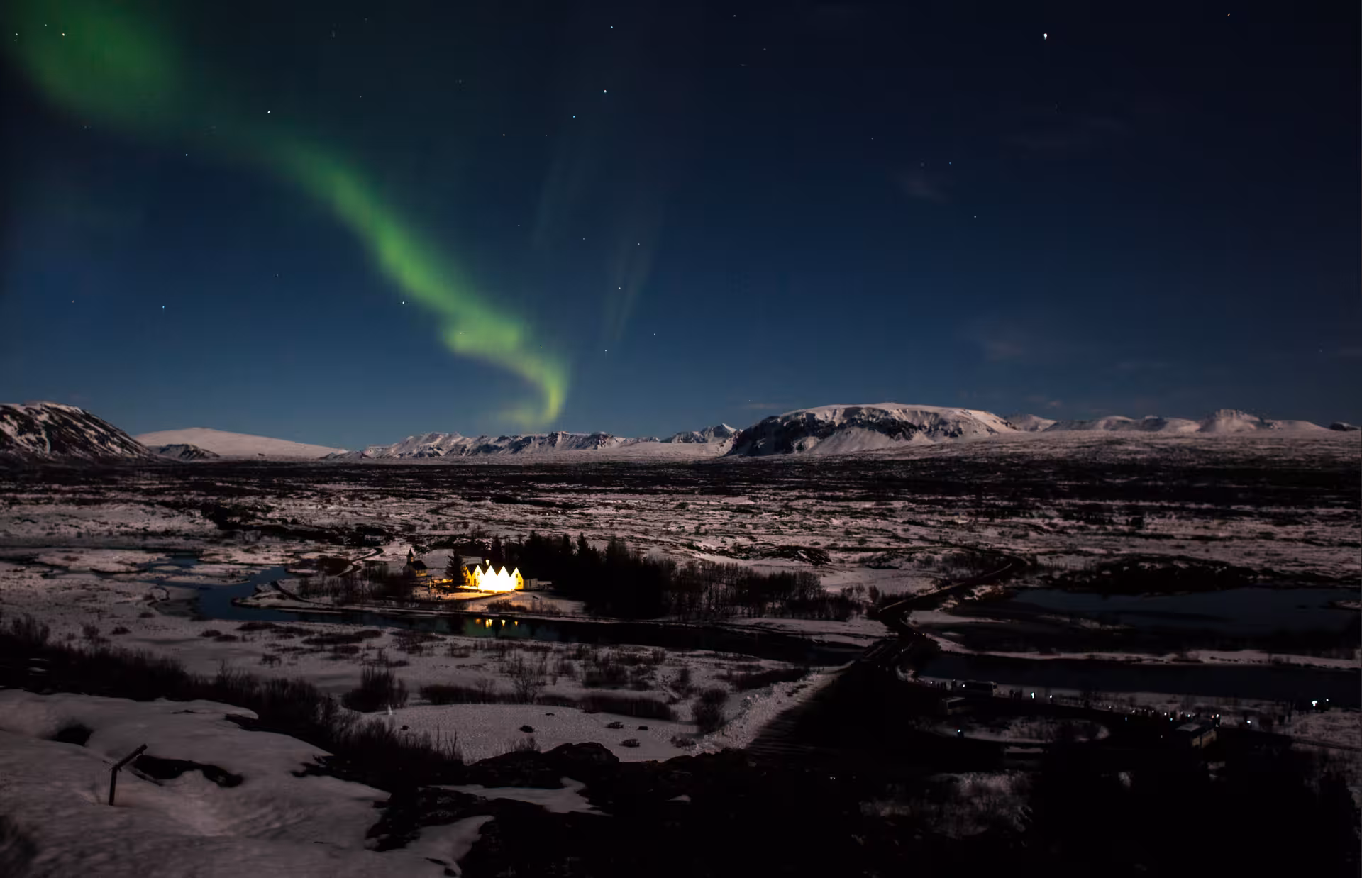 Stunning Northern Lights over snow-covered landscape, perfect for a private 4x4 Super Truck adventure tour.