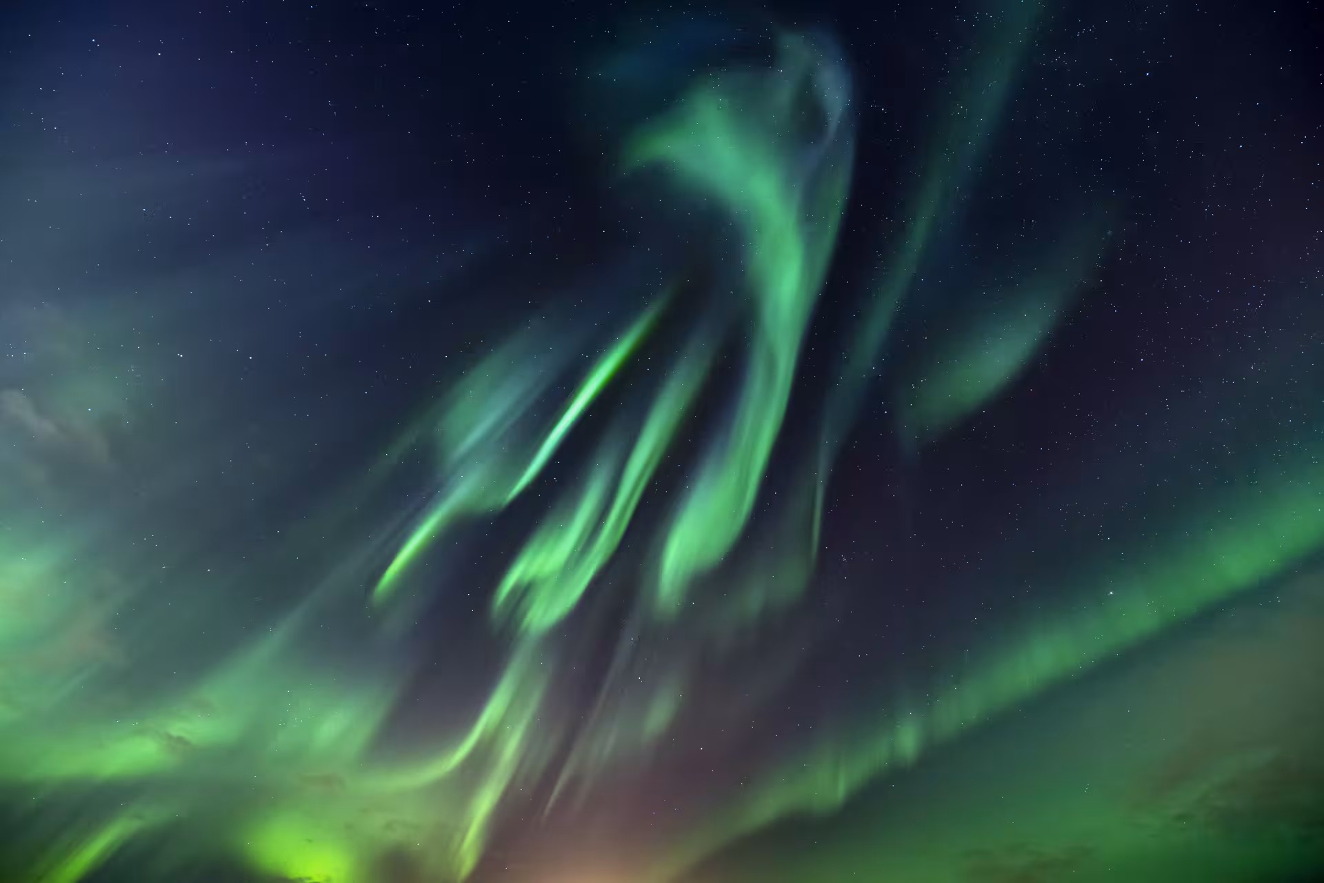 Vivid green auroras dance across the starry night sky in Reykjavík, offering a mesmerizing Northern Lights experience.