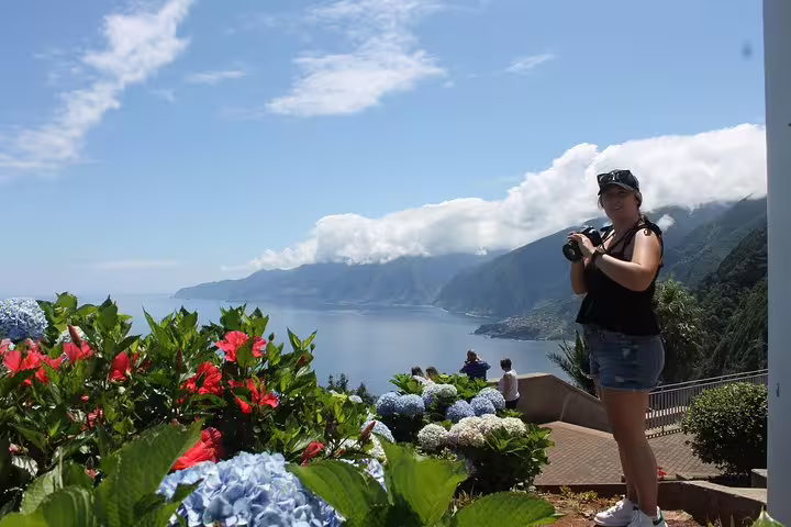 Tourist enjoys breathtaking view of lush Northwest Terraces and stunning volcanic pools on an adventurous 4x4 tour.