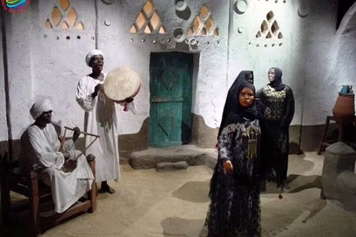 Nubian Museum Aswan exhibit showing traditional music scene with drum and local figures on guided tour