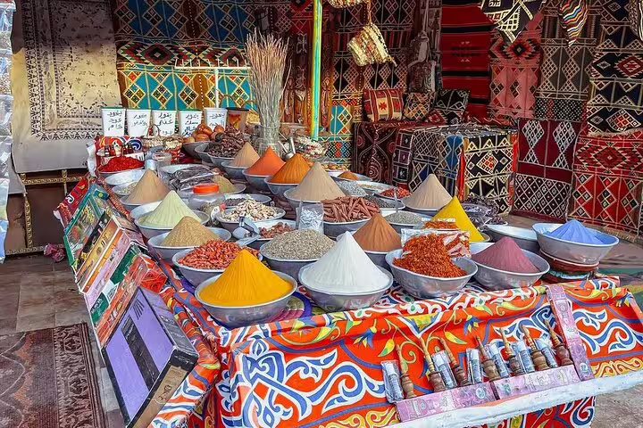Nubian Village spice stall in Aswan with colorful pyramids of spices, part of private motorboat tour with guide