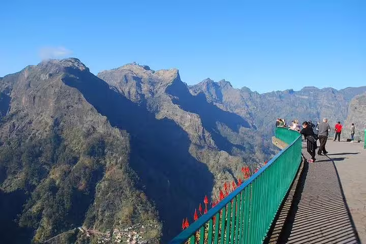 Visitors enjoy stunning views of Nun's Valley's rugged mountainous landscape from a high vantage point in Madeira.