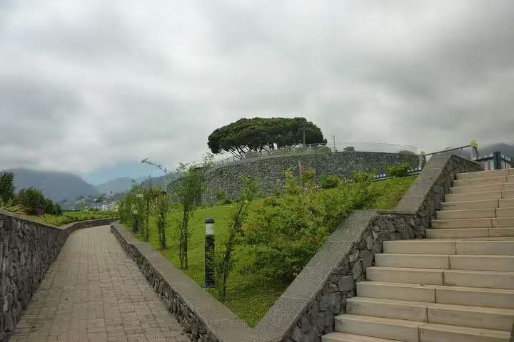 Scenic view of Nun's Valley with a stone path, lush greenery, and misty mountains in the background.