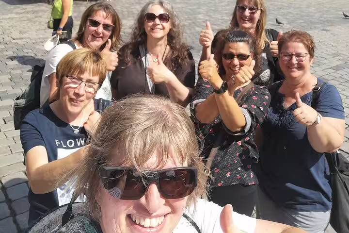 Smiling friends in Nuremberg Old Town square, celebrating clues on a self-guided scavenger hunt tour