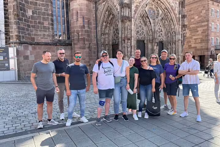 Travelers pose by Nuremberg St. Lorenz Church on a self-guided scavenger hunt city sights tour
