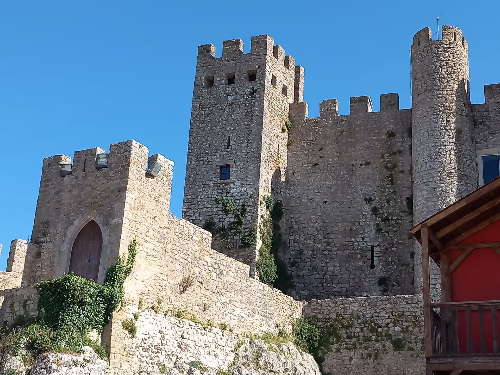 Close-up of Óbidos Castle towers and ramparts, highlight stop on private transfer from Porto to Lisbon with Nazaré