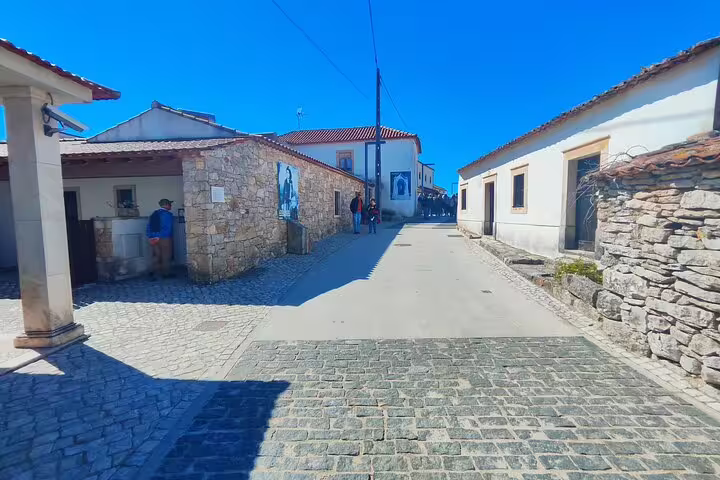 Charming cobblestone street in Óbidos with rustic stone buildings under a clear blue sky, ideal for cultural exploration.