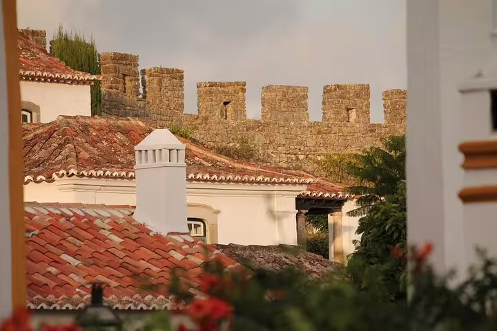 Scenic view of Óbidos' medieval walls and charming terracotta rooftops, capturing the essence of Portugal's historic architecture.