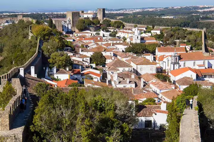 Scenic view of Obidos with medieval walls and charming white houses, featured in Private Day Tour to Fatima, Batalha, Nazaré.