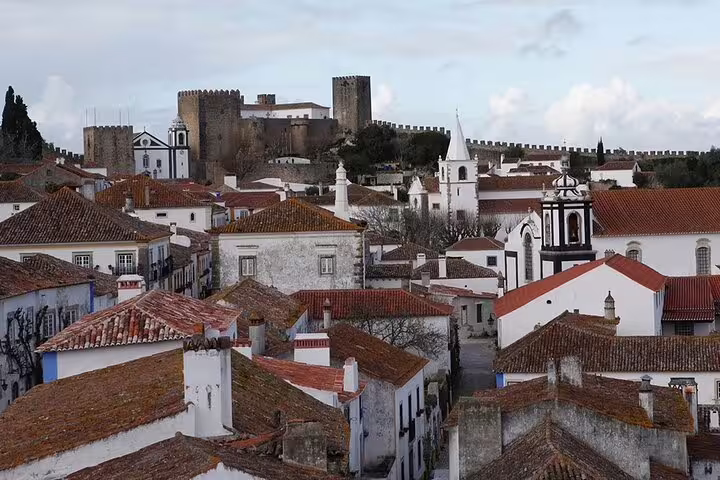 Scenic view of medieval Obidos village with red-tiled roofs and castle, perfect for a private half-day tour to Nazare and Obidos.
