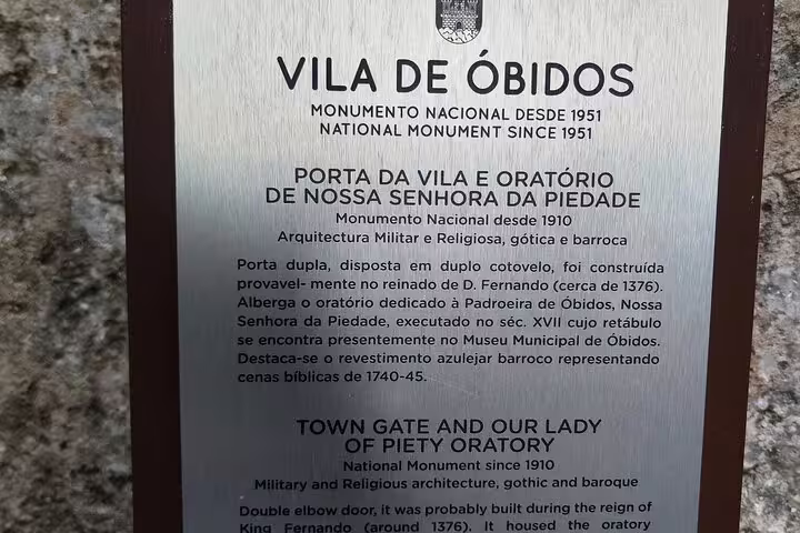 Plaque detailing the history of Vila de Óbidos, a national monument showcasing Gothic and Baroque architecture.