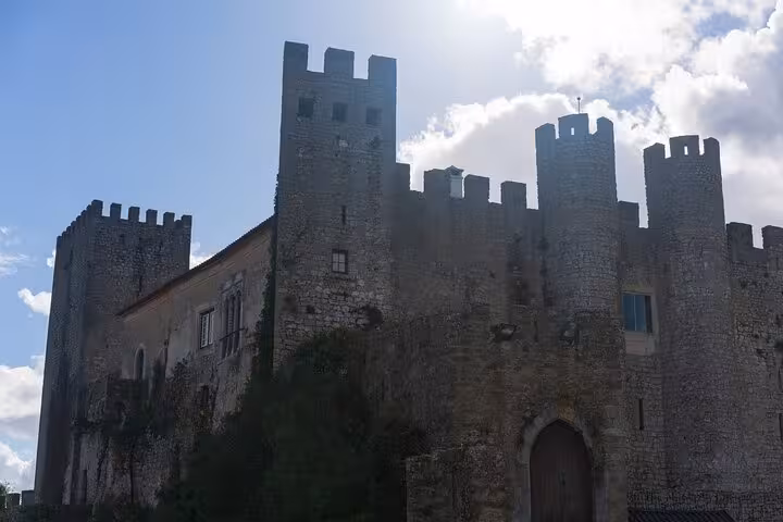 Historic stone castle in Obidos basking in sunlight, a highlight of cultural exploration on a private tour.