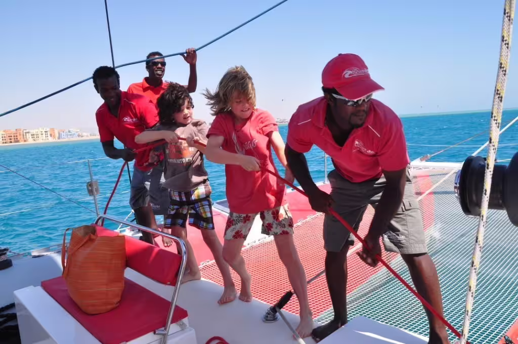 Guests and crew pull ropes on Ocean Diva Catamaran, enjoying a fun Red Sea sailing trip in Hurghada