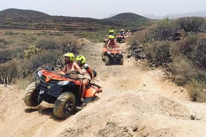 Adventurers on an exciting off-road quad biking tour navigate rugged trails with stunning desert landscapes.
