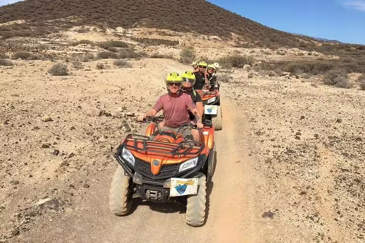 Adventurers enjoy a thrilling quad biking tour on rugged desert trails, showcasing off-road excitement.