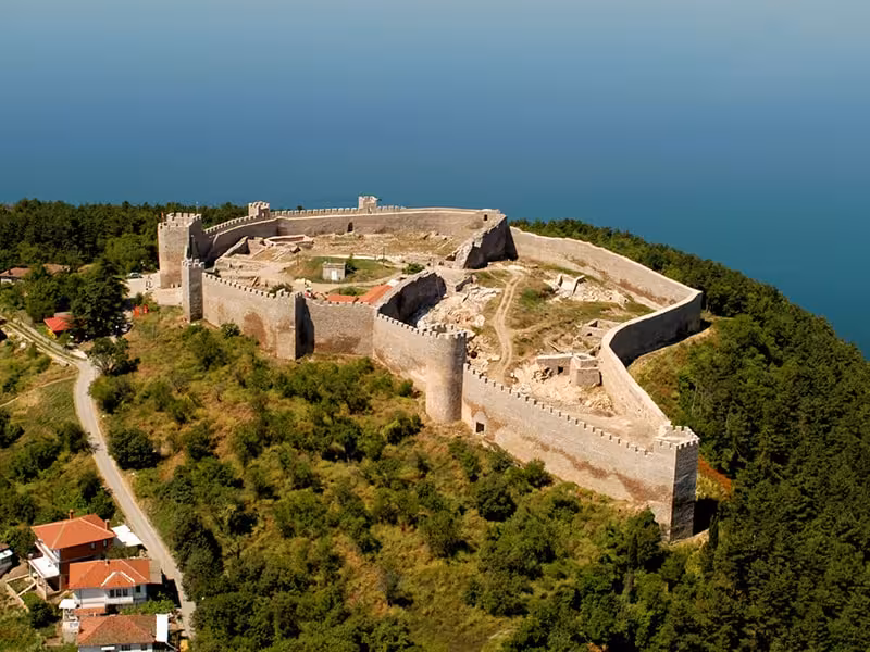 Scenic aerial view of a historic castle on Lake Ohrid's edge, offering stunning vistas and a glimpse into Macedonian history.