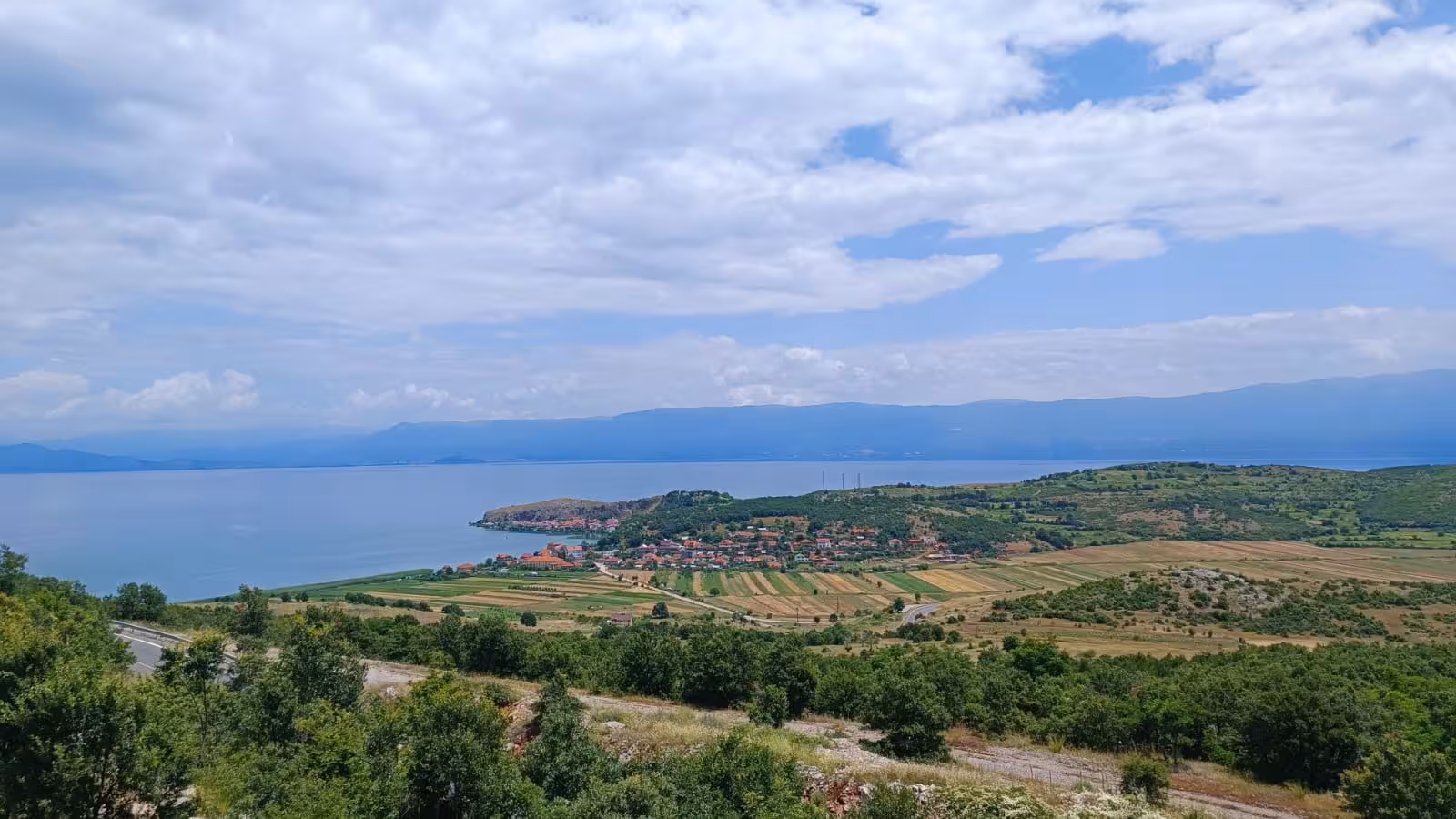 Scenic view of Ohrid Lake and surrounding fields in North Macedonia, highlighting the natural beauty on a Balkan tour.