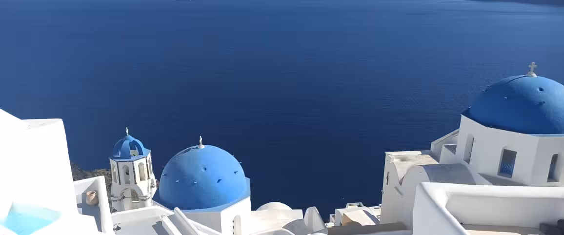 Oia cliffside blue domes overlooking the Santorini caldera, a must-see viewpoint on the iconic highlights tour