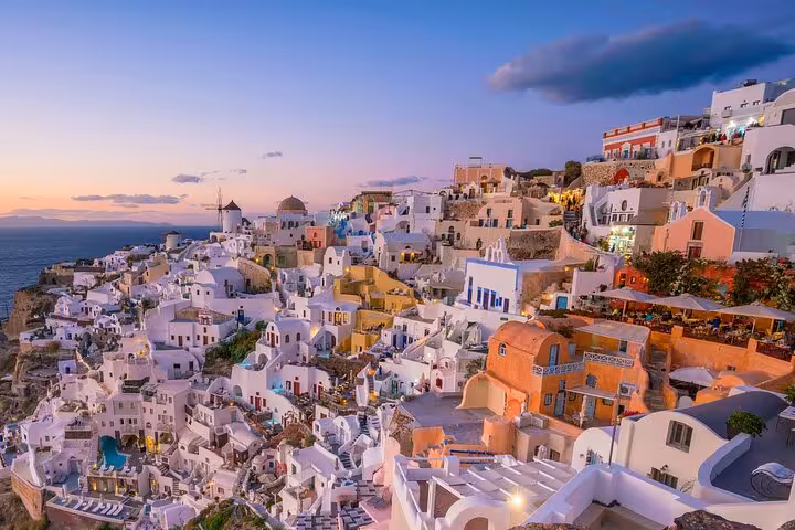 Oia Santorini sunset panorama with iconic whitewashed village and domes on a private half-day tour