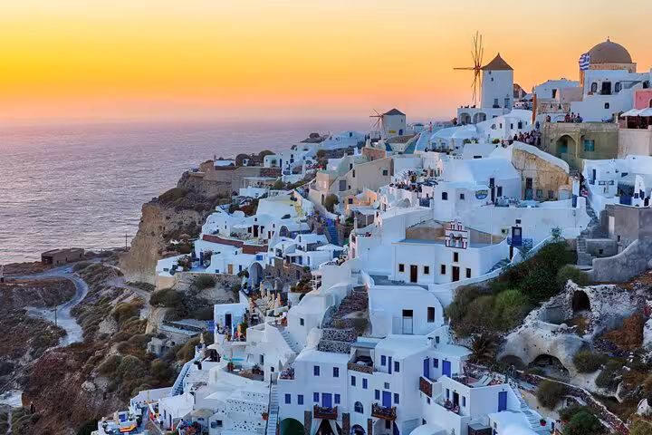 Oia Santorini sunset over whitewashed cliffside houses and windmill, included in 2-day Athens tour