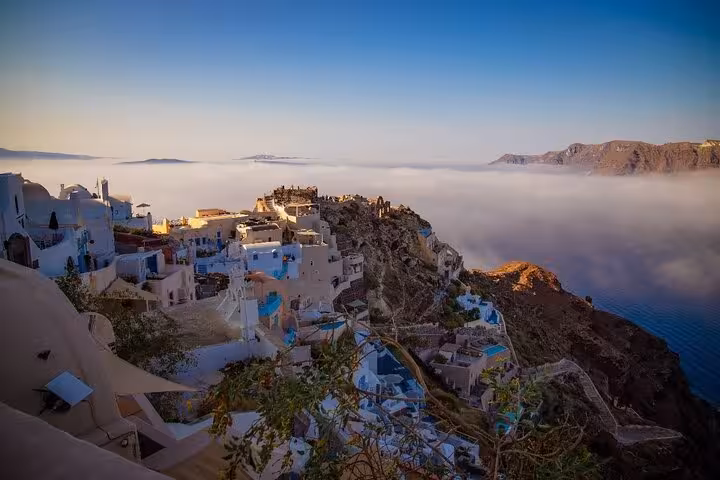 Golden hour in Oia, Santorini with cliffside whitewashed houses above the caldera, top cruise guest tour view