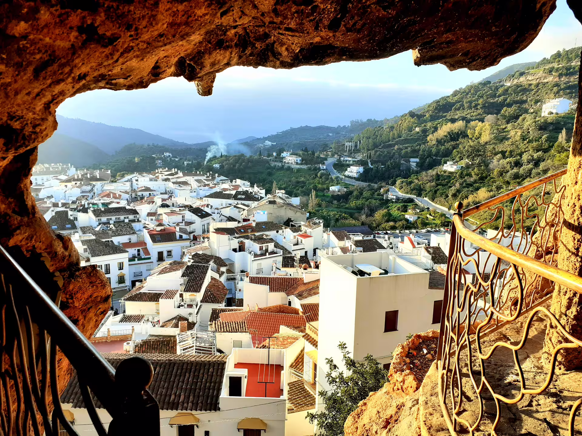 View of Ojen from a cave lookout on a private Costa del Sol tour, with white village rooftops and mountain valley