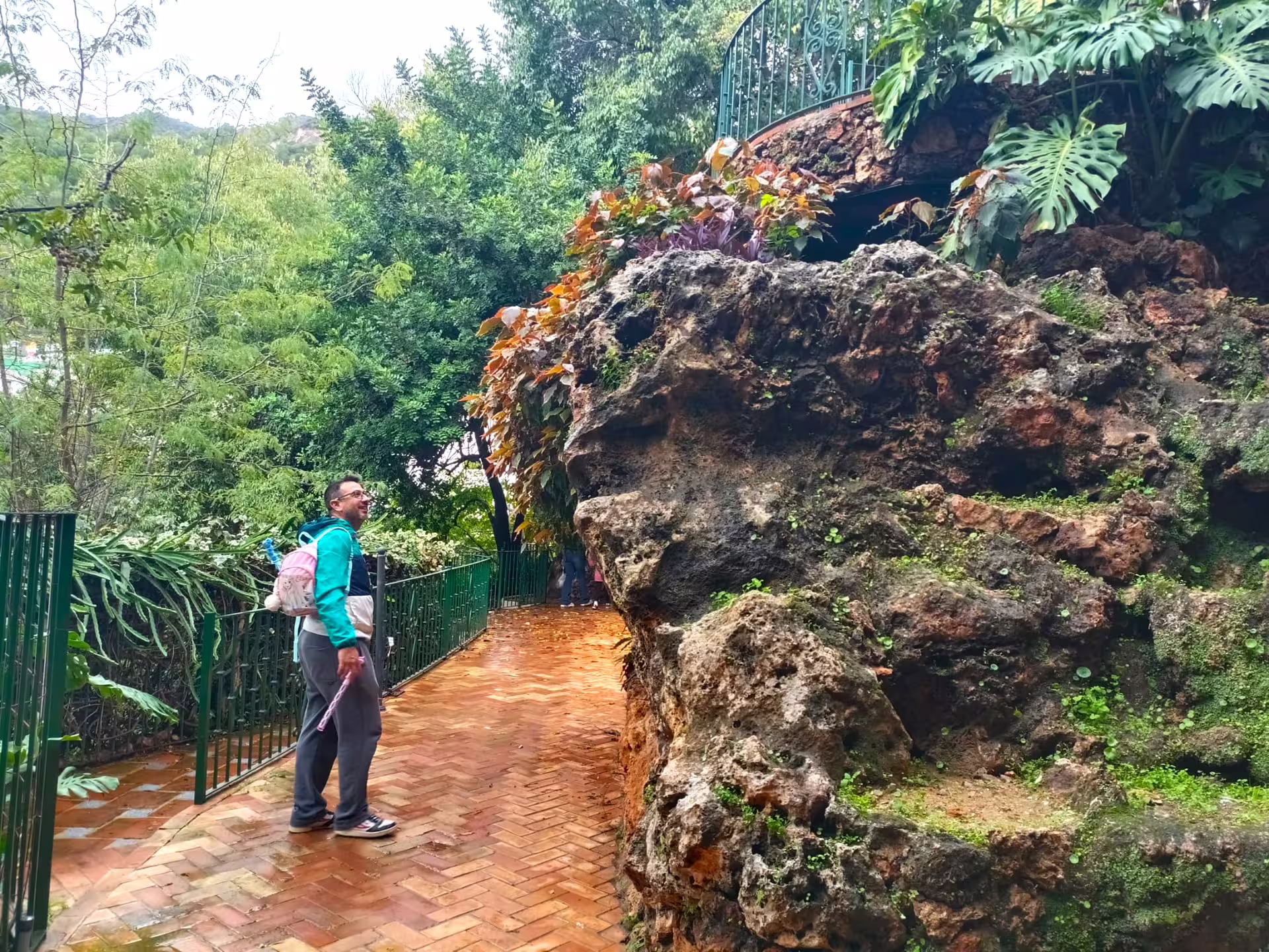 Traveler explores a lush garden path and rock grotto in Ojen on a private tour from Costa del Sol day trip
