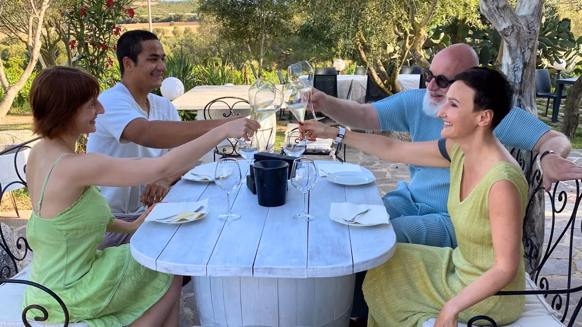 Friends toasting with wine in a serene outdoor setting at Gallura winery, perfect for Olbia's vineyard gatherings.