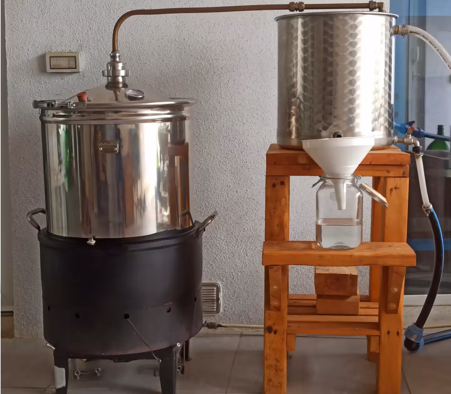 Traditional gin distillation setup in Olbia showcasing copper stills and glass jars for an authentic craft experience.
