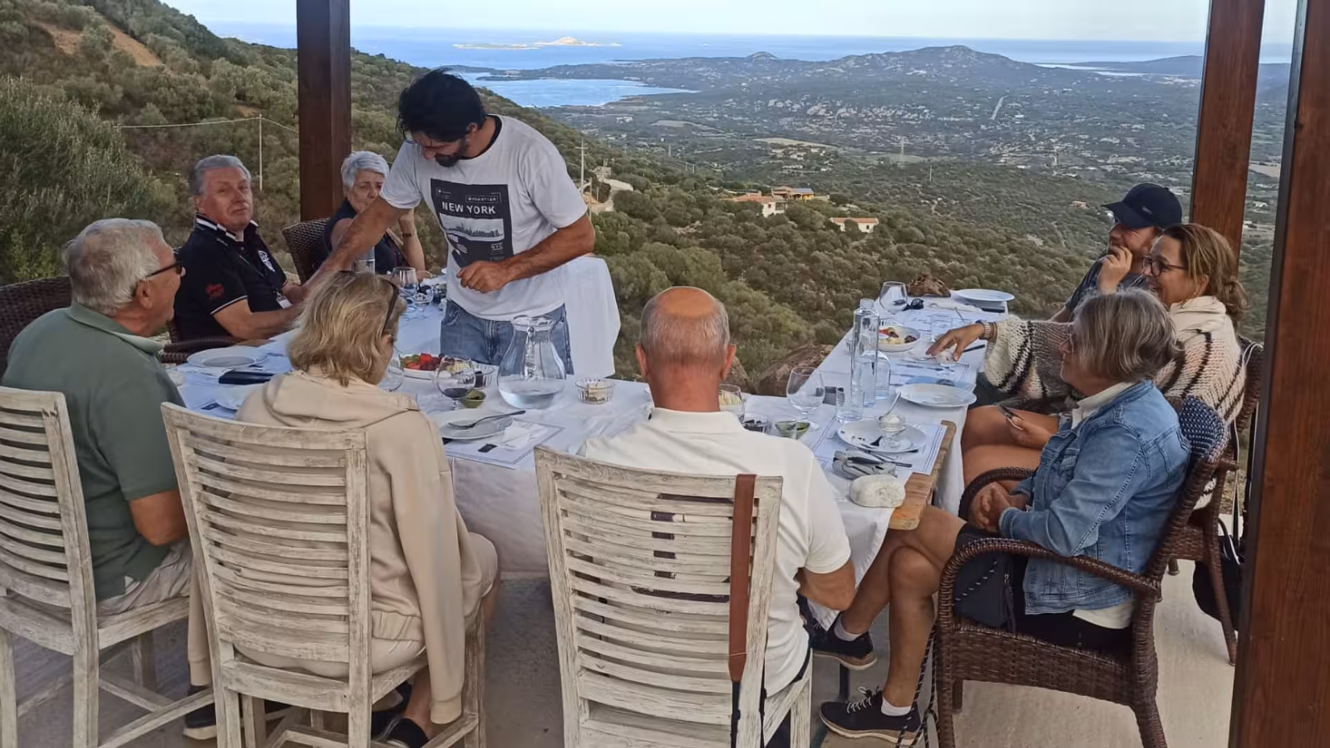 Group enjoying a myrtle tasting experience with stunning views of Olbia's landscape.
