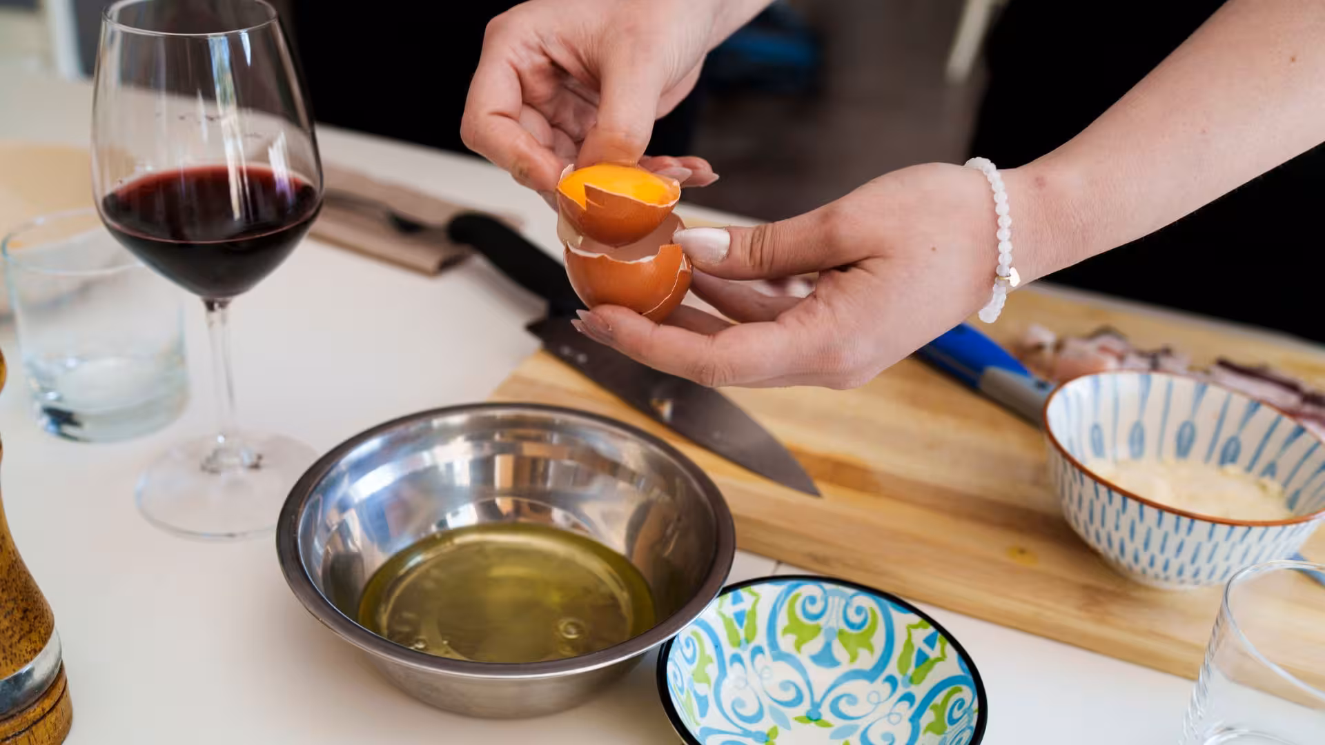 A participant skillfully separates egg yolk for a traditional pasta carbonara in Olbia's cooking workshop.