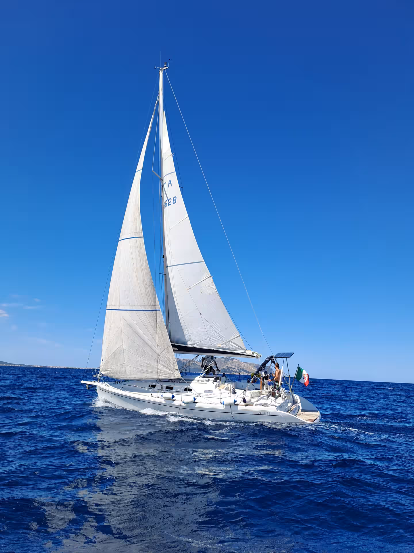 Sailing yacht gliding through the deep blue sea on an Olbia tour between Tavolara and Cala Moresca.