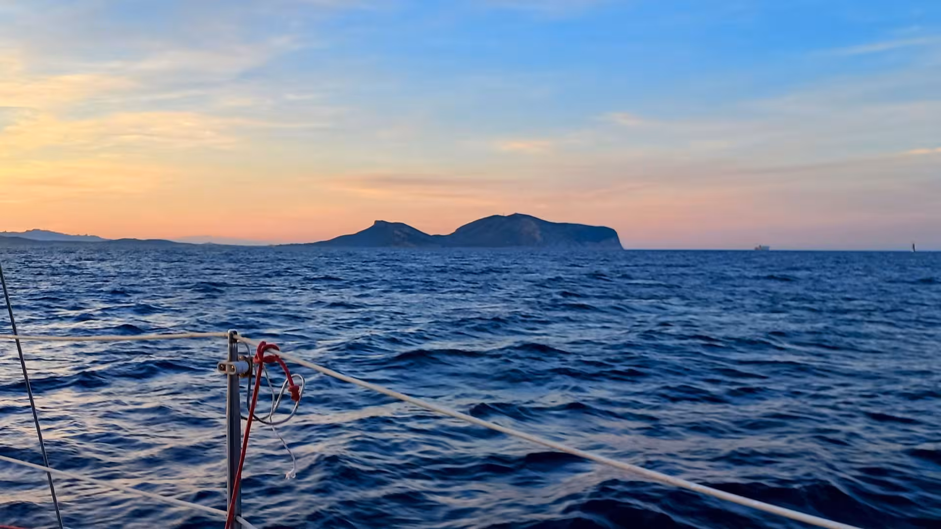 Experience a breathtaking sunset over the sea during the Olbia catamaran tour, with serene waters and distant islands.