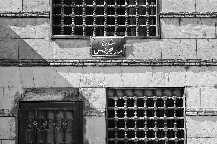 Old Cairo street facade with Arabic sign and traditional mashrabiya windows on a private walking tour
